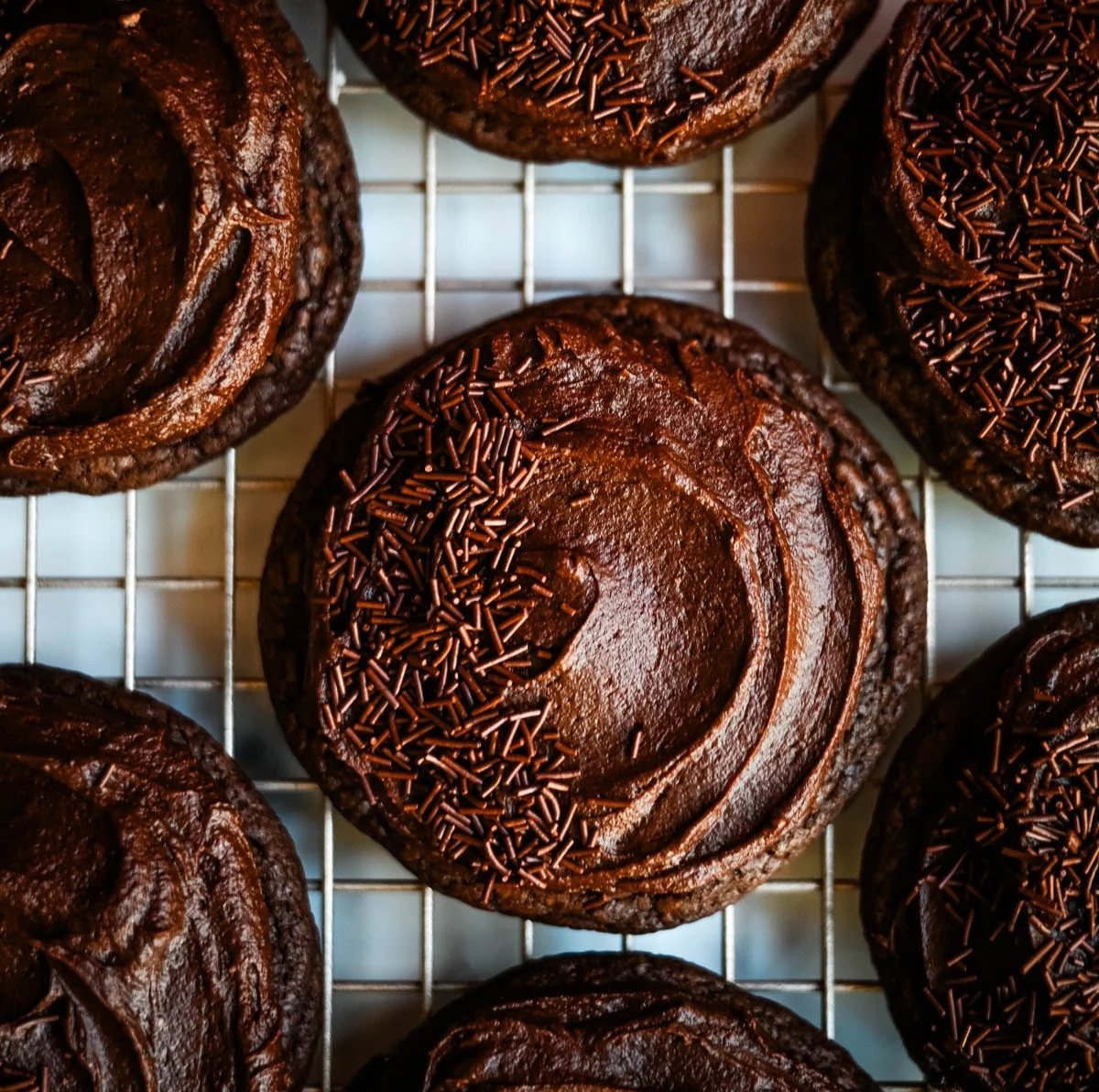 These easy Chocolate Frosted Cookies combine soft chocolate cookies with a rich, chocolate buttercream frosting. The double chocolate cookie base is filled with melty chocolate chips and a smooth cocoa frosting on top. These Frosted Chocolate Cookies are a chocolate lover’s dream.