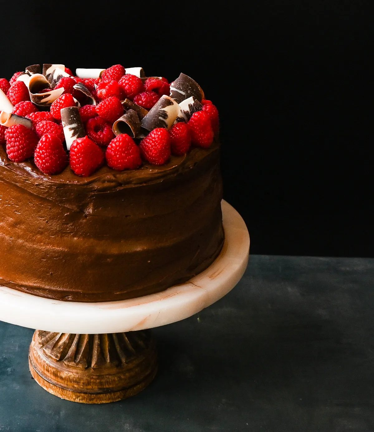 This is the Best Chocolate Raspberry Cake Recipe. Rich layered chocolate cake with whipped cream cheese raspberry filling, topped with creamy chocolate buttercream frosting and fresh raspberries.