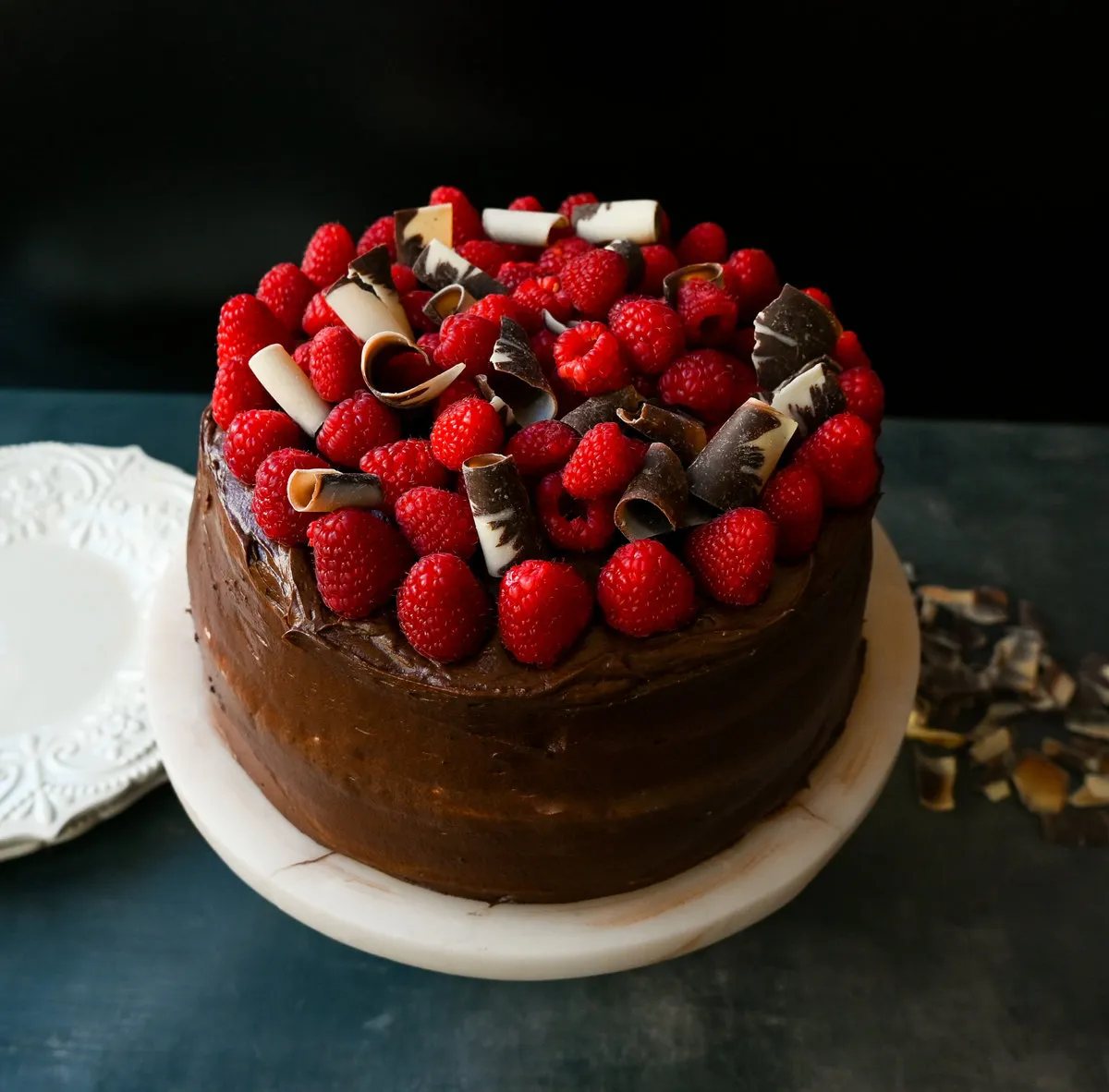 This is the Best Chocolate Raspberry Cake Recipe. Rich layered chocolate cake with whipped cream cheese raspberry filling, topped with creamy chocolate buttercream frosting and fresh raspberries.