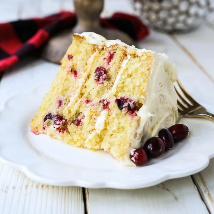 Cranberry Orange Cake. A moist orange zest cake with fresh cranberries with a sweet cream cheese orange frosting. A sweet yet tart holiday cake. www.modernhoney.com #cranberry #cranberrycake #cranberryorange #cranberryorangecake