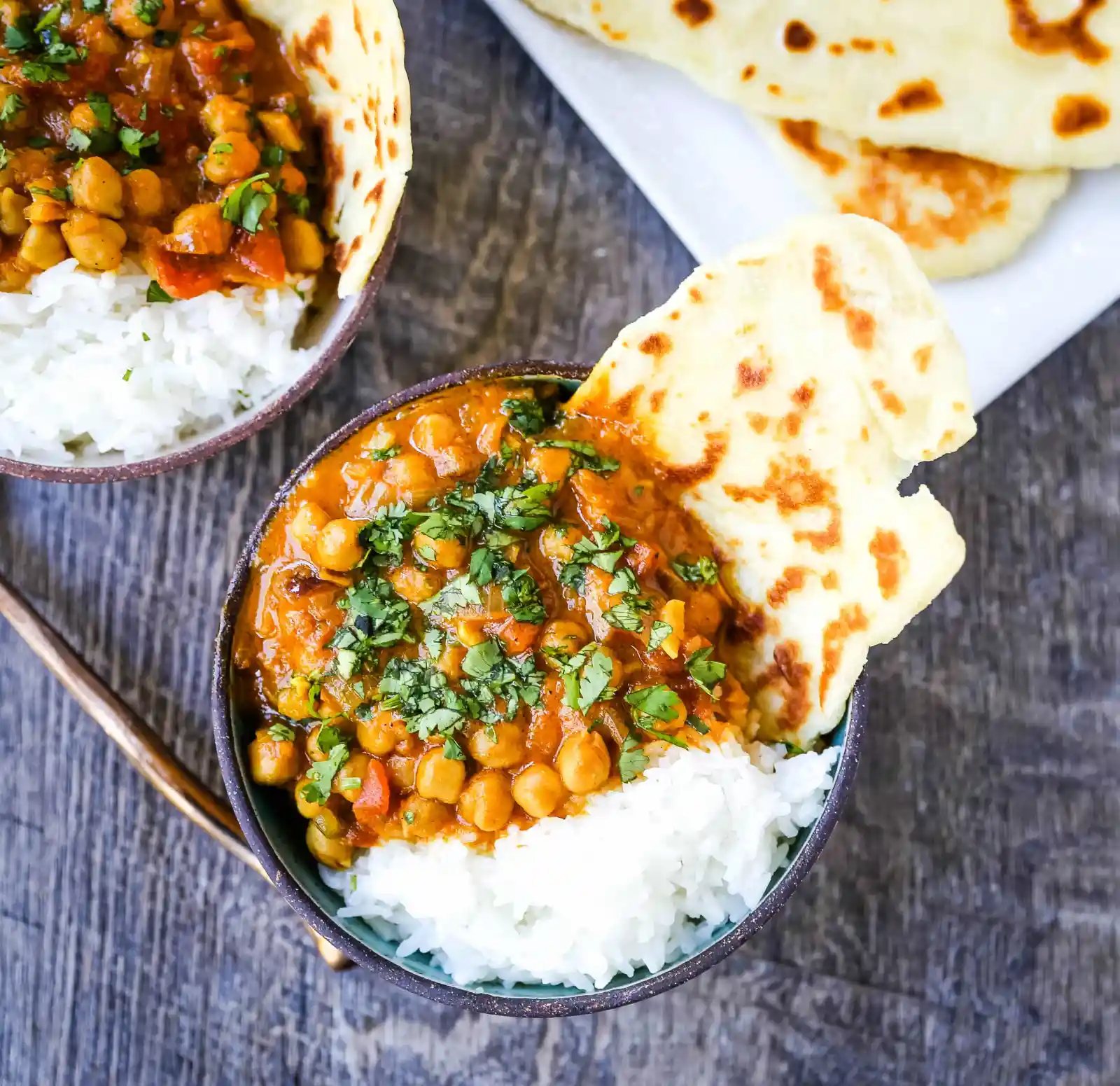Coconut Chickpea Curry A rich coconut curry broth with onion, garlic, ginger, Indian spices in coconut milk and tossed with chickpeas. Flavorful vegan meal and you won't even miss the meat! www.modernhoney.com #vegan #curry #indianfood #vegancurry #chickpeacurry