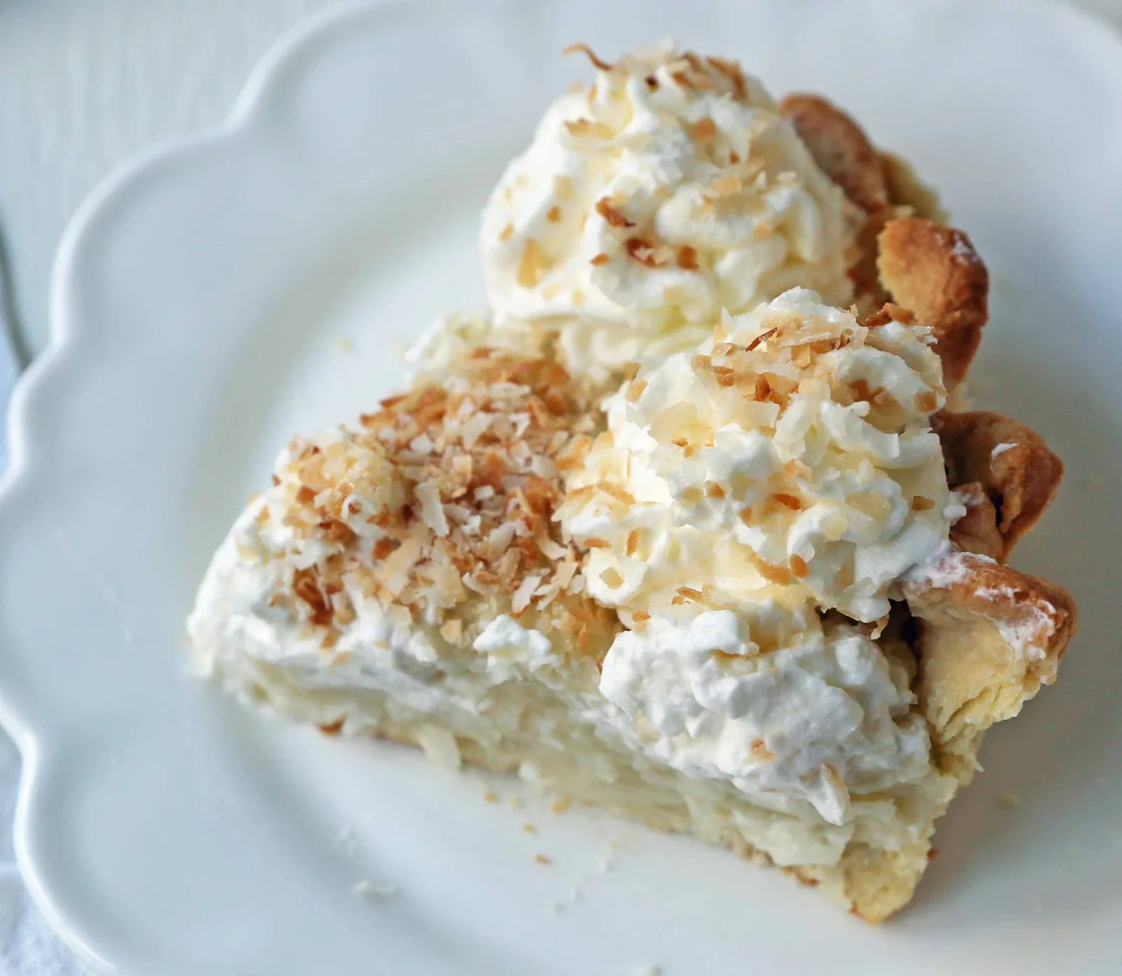 Coconut Cream Pie. A homemade coconut custard filling in a buttery pie crust topped with fresh whipped cream and toasted coconut. www.modernhoney.com #coconutcreampie #coconutpie #pie