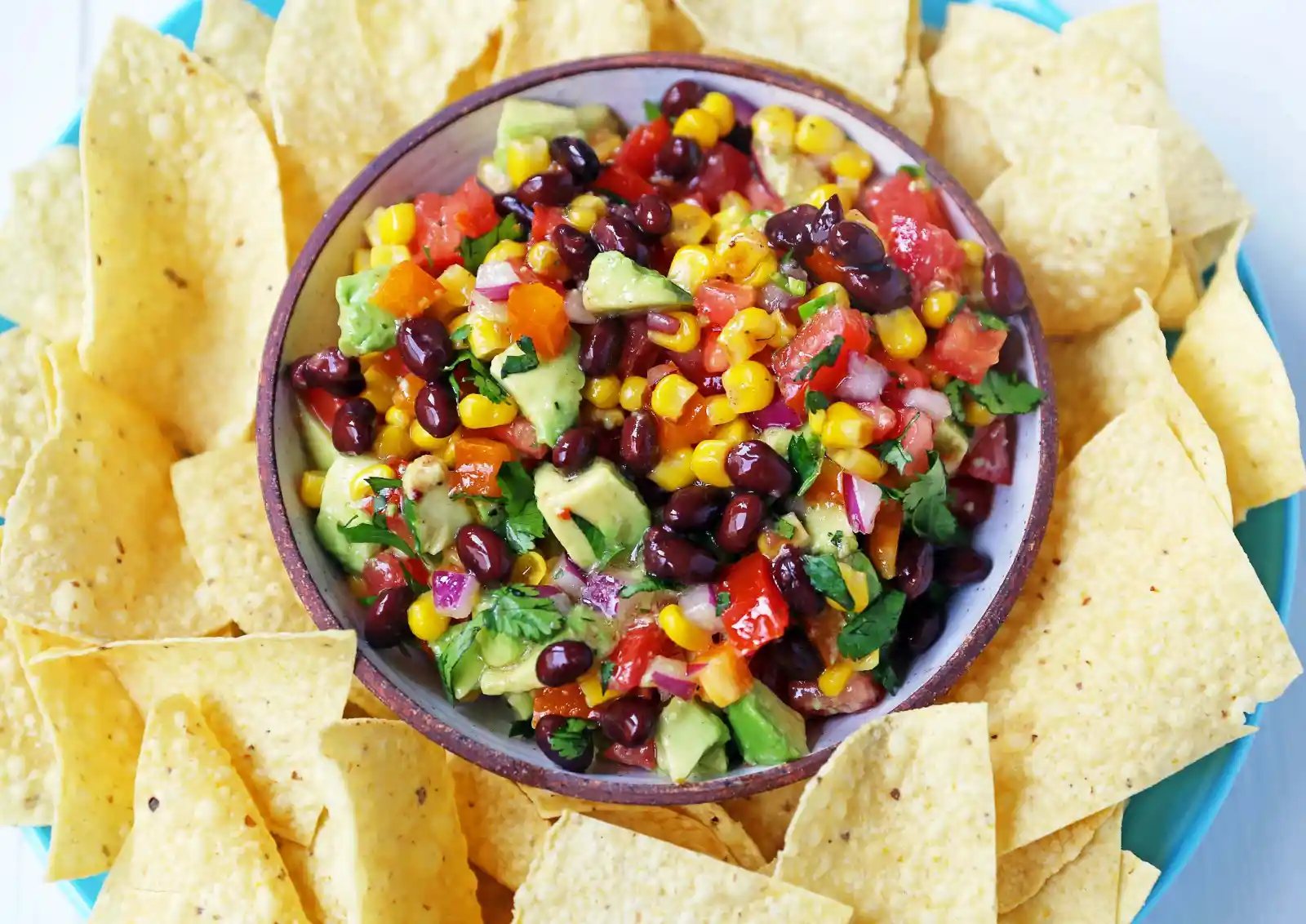Cowboy Caviar. A popular, crowd-pleasing appetizer made with black beans, corn, tomatoes, cilantro, avocado, peppers, all tossed in a zesty dressing. www.modernhoney.com #cowboycaviar #appetizer #salsa #cornsalsa #blackbeansalsa #appetizers