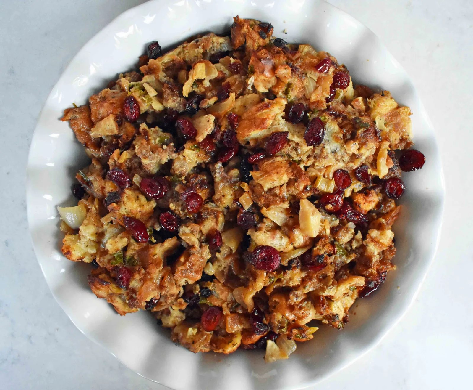 Cranberry Apple Sausage Stuffing by Modern Honey. Classic Bread Stuffing with Sausage, Dried Cranberries, and Crisp Apples. The perfect Thanksgiving side dish recipe!