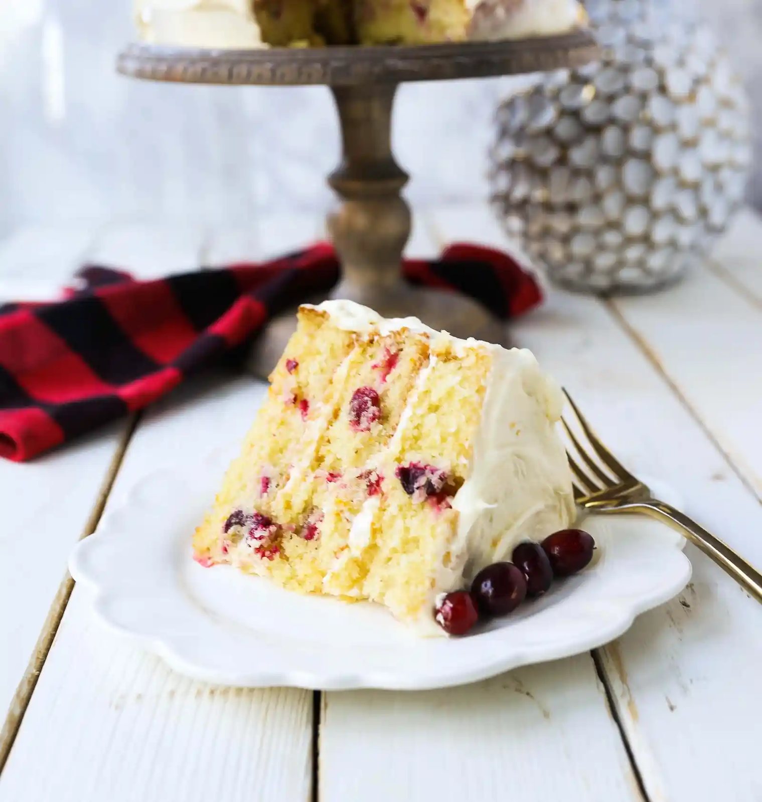 Cranberry Orange Cake. A moist orange zest cake with fresh cranberries with a sweet cream cheese orange frosting. A sweet yet tart holiday cake. www.modernhoney.com #cranberry #cranberrycake #cranberryorange #cranberryorangecake