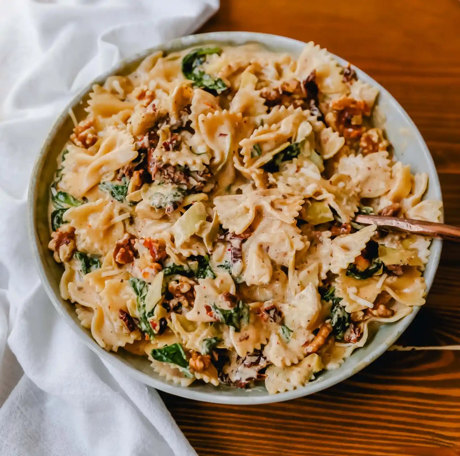 Creamy Bowtie Pasta with Sundried Tomatoes Bowtie Pasta tossed with a garlic sundried tomato cream sauce with artichoke hearts and parmesan cheese and crunchy toasted walnuts. A quick 20-minute weeknight meal. #pasta #dinner