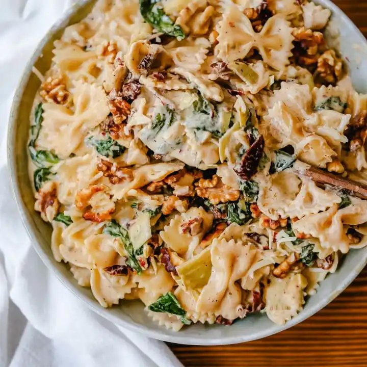 Creamy Bowtie Pasta with Sundried Tomatoes Bowtie Pasta tossed with a garlic sundried tomato cream sauce with artichoke hearts and parmesan cheese and crunchy toasted walnuts. A quick 20-minute weeknight meal. #pasta #dinner
