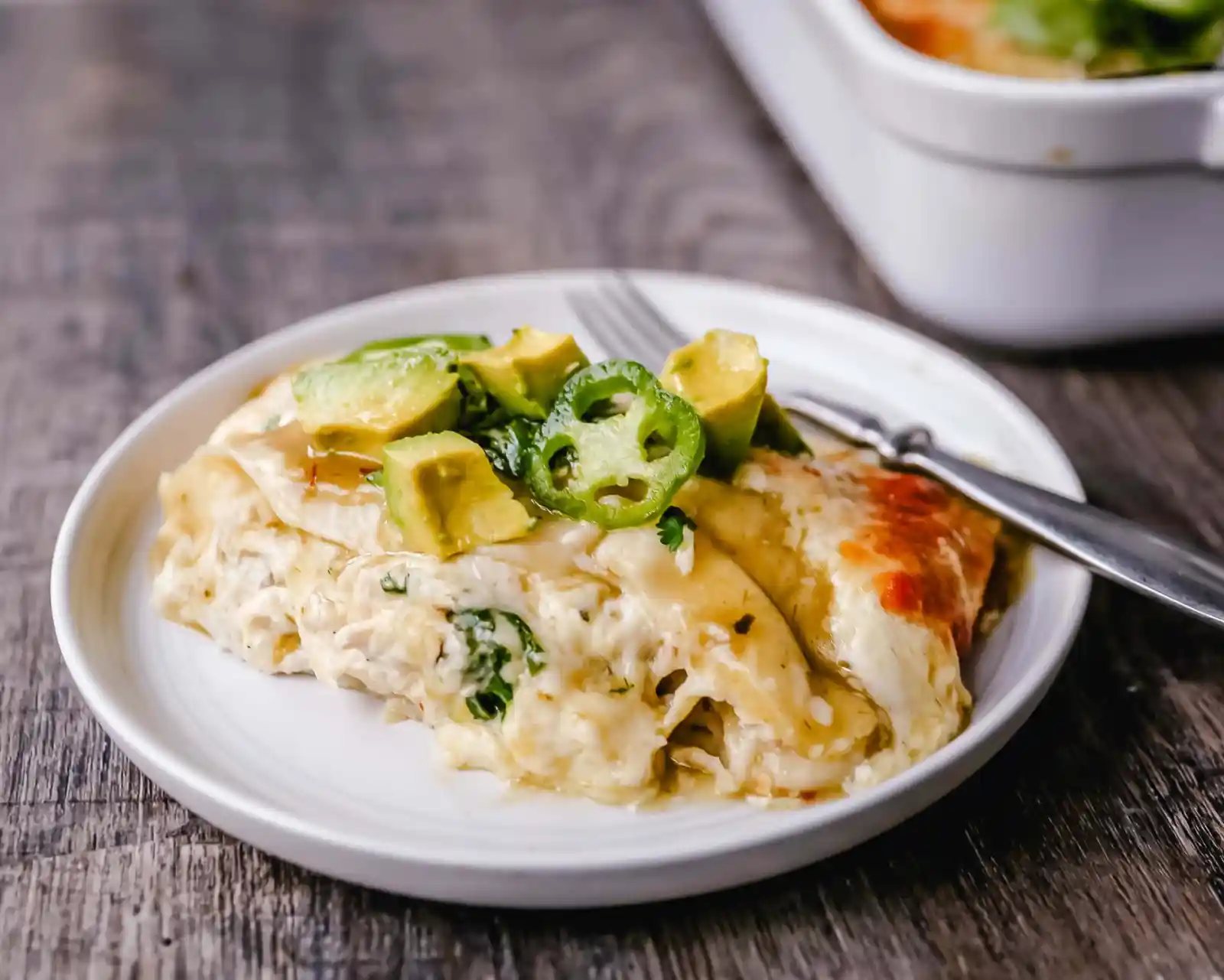 Creamy Green Chile Chicken Enchiladas Creamy chicken enchiladas stuffed with a cream cheese and sour cream green chile chicken rolled into corn tortillas and topped with green enchilada sauce and pepper jack cheese. The best creamy chicken enchiladas recipe! www.moderrnhoney.com #enchiladas #mexicanfood
