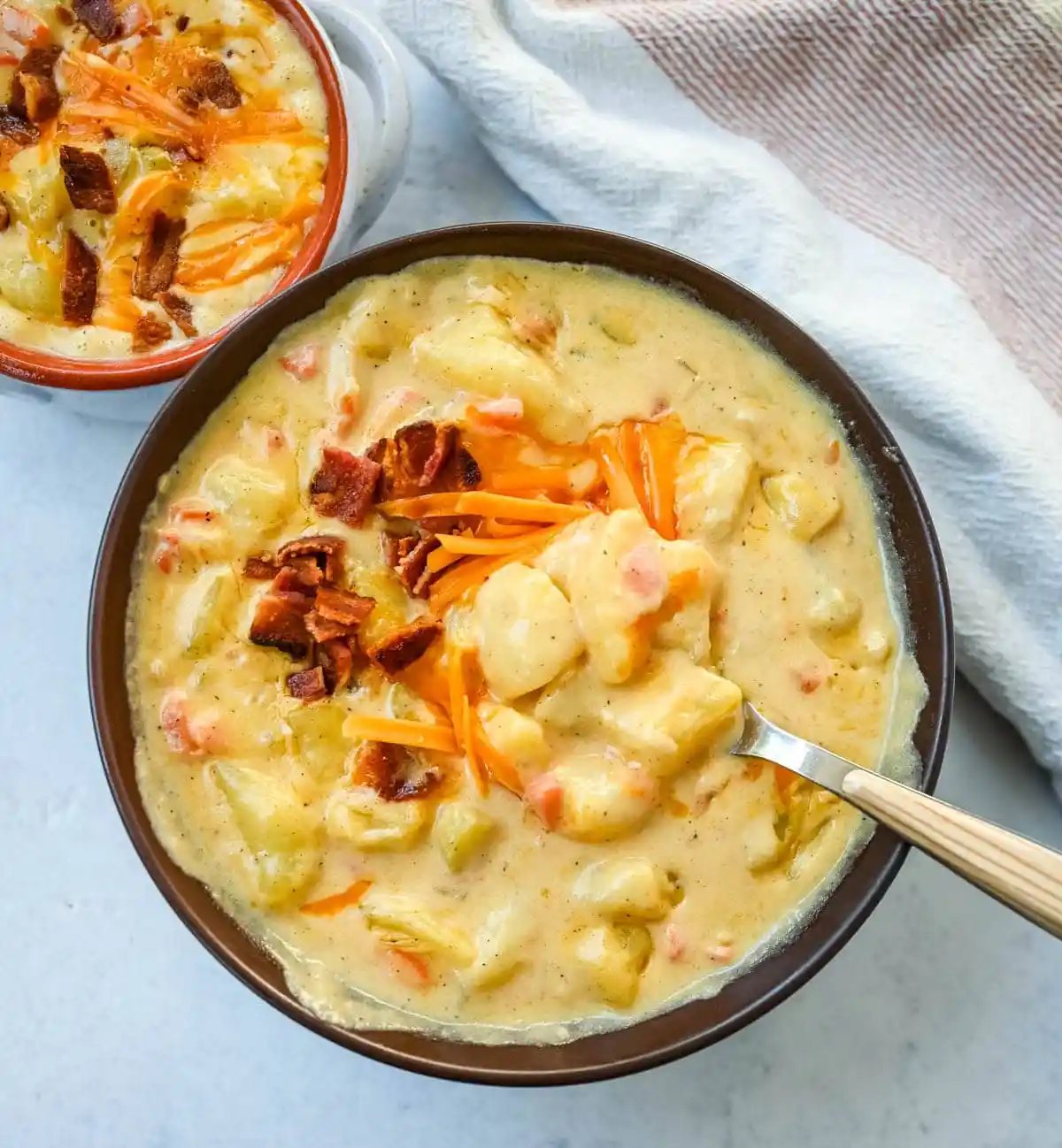 This creamy potato soup is the definition of comfort in a bowl made with buttery Yukon gold potatoes, crispy bacon, cheddar cheese, and a splash of heavy cream come together to make the richest, coziest soup ever. You will love this Potato Cheese Soup Recipe!