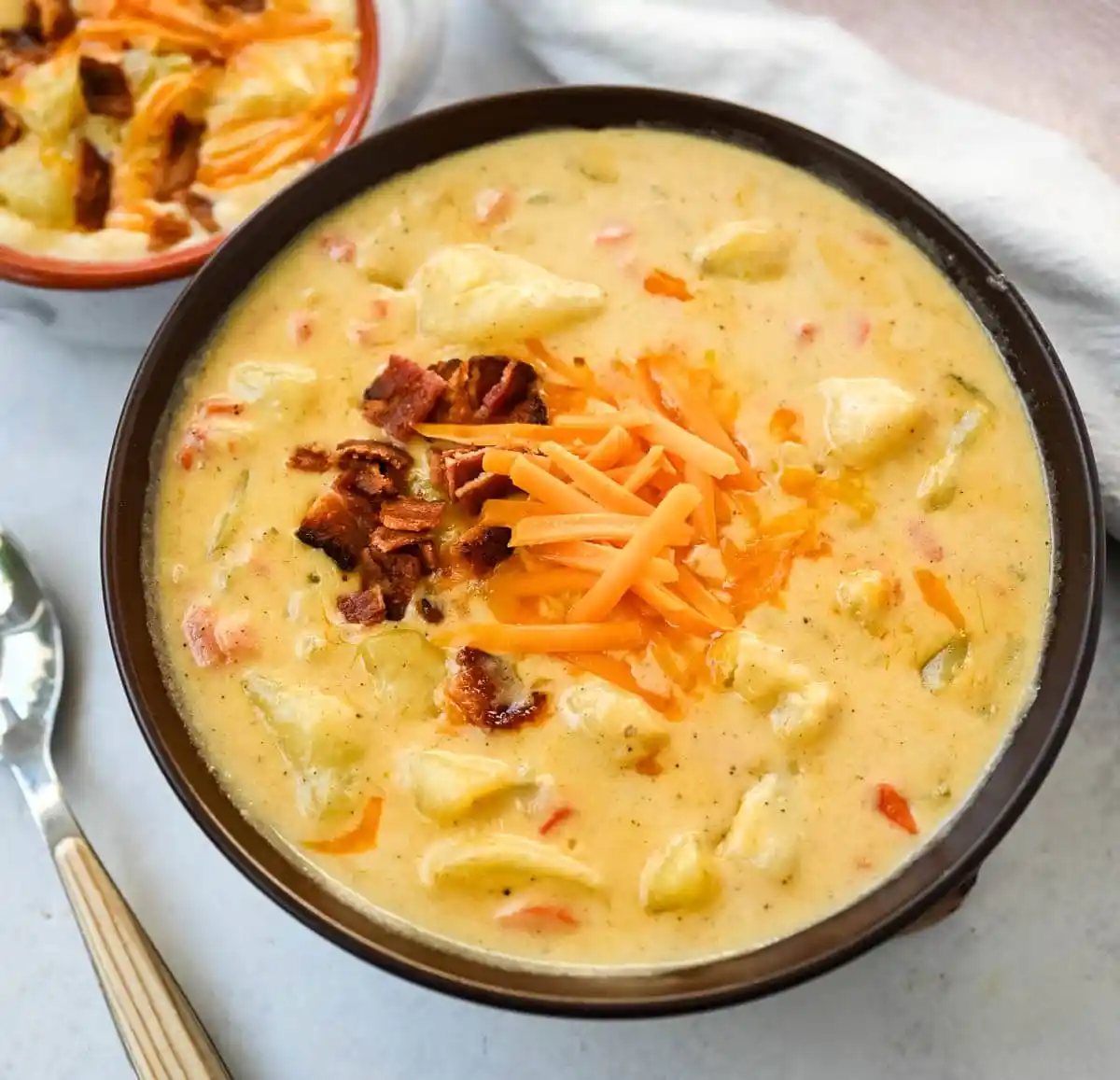 This creamy potato soup is the definition of comfort in a bowl made with buttery Yukon gold potatoes, crispy bacon, cheddar cheese, and a splash of heavy cream come together to make the richest, coziest soup ever. You will love this Potato Cheese Soup Recipe!