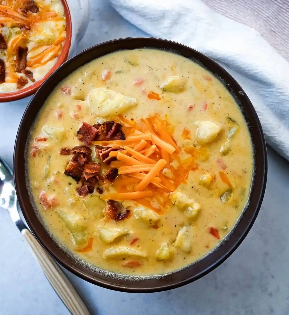 This creamy potato soup is the definition of comfort in a bowl made with buttery Yukon gold potatoes, crispy bacon, cheddar cheese, and a splash of heavy cream come together to make the richest, coziest soup ever. You will love this Potato Cheese Soup Recipe!