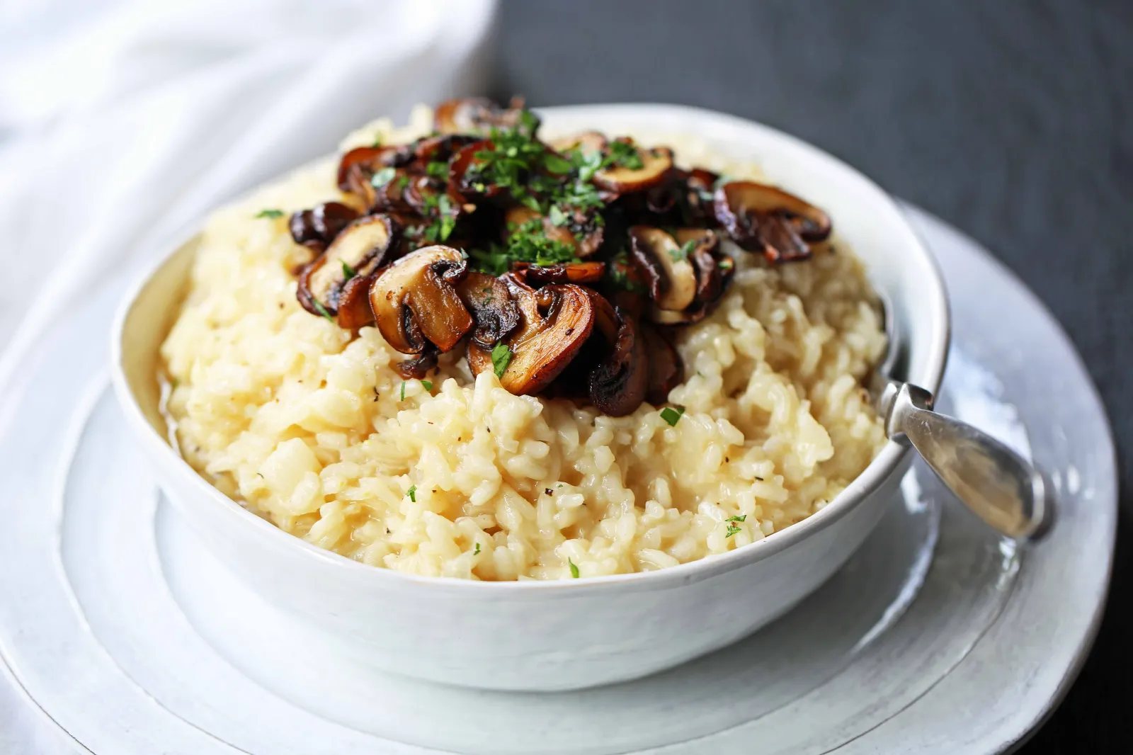 Creamy Mushroom Risotto. Rich, creamy rice slowly simmered with chicken broth, butter, parmesan cheese, and topped with butter sauteed mushrooms. www.modernhoney.com #risotto #homemaderisotto #mushroomrisotto