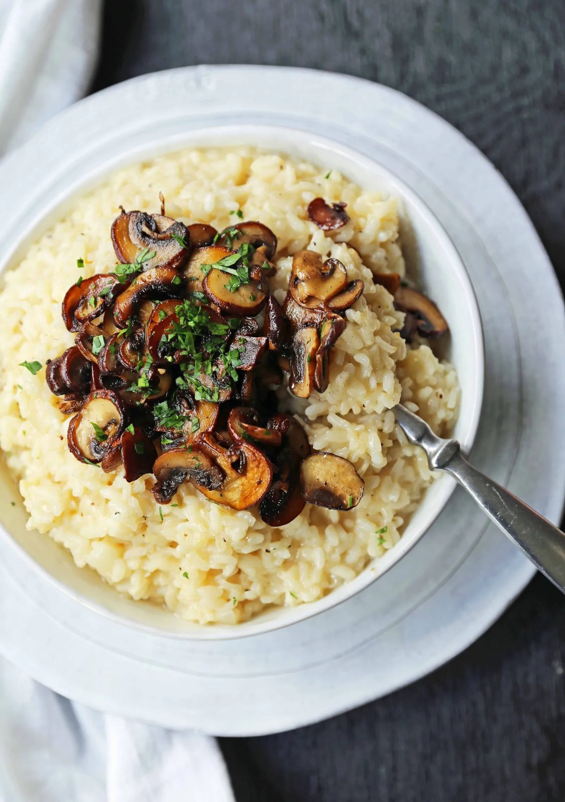 Creamy Mushroom Risotto. Rich, creamy rice slowly simmered with chicken broth, butter, parmesan cheese, and topped with butter sauteed mushrooms. www.modernhoney.com #risotto #homemaderisotto #mushroomrisotto