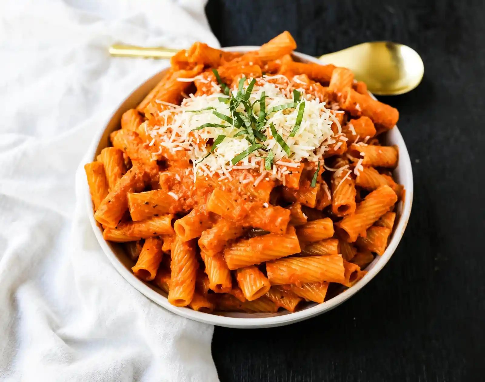Creamy Roasted Red Pepper Pasta A creamy roasted red pepper and tomato basil sauce with garlic and heavy cream all tossed together with pasta and topped with parmesan cheese. A flavorful robust pasta dish! www.modernhoney.com #pasta #italian #italianfood