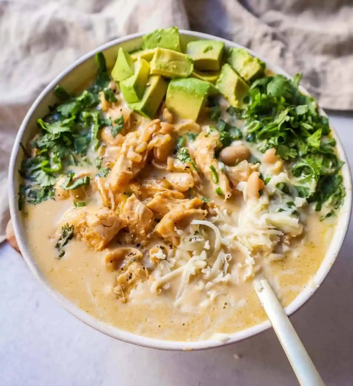 The Best White Chicken Chili Recipe made with shredded chicken, jalapeno, onion, spices, in a creamy chicken broth with salsa verde, cream cheese, white beans, shredded cheese, and fresh cilantro. The perfect creamy white chicken chili recipe!