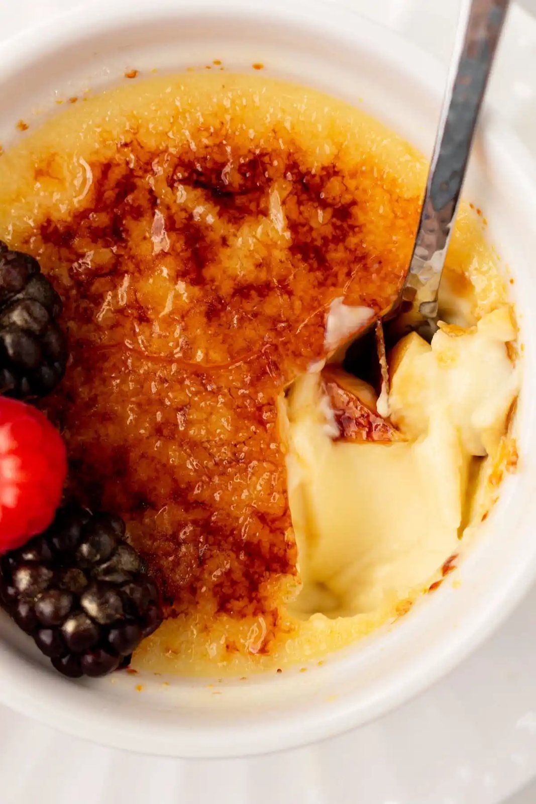 A spoon dishing out creme brulee. A creamy, silky vanilla custard topped with crisp sugar crust is one of the most popular desserts at restaurants for good reason. With its silky custard base and crackly caramelized sugar topping, it’s a showstopper that’s surprisingly easy to make at home.