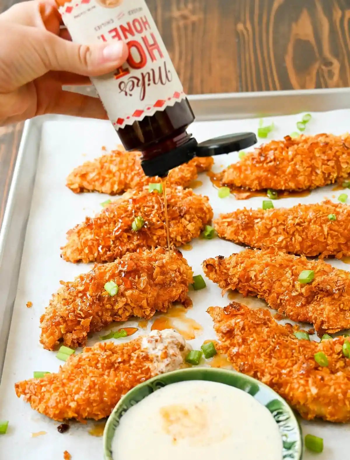 Tender, juicy chicken coated in a crispy cornflake crust that is baked to golden perfection, and then drizzled with sweet and spicy hot honey. These Crispy Crunchy Hot Honey Chicken Tenders deliver the perfect balance of crunch and heat, with a mouthwatering sticky glaze that keeps you coming back for more.