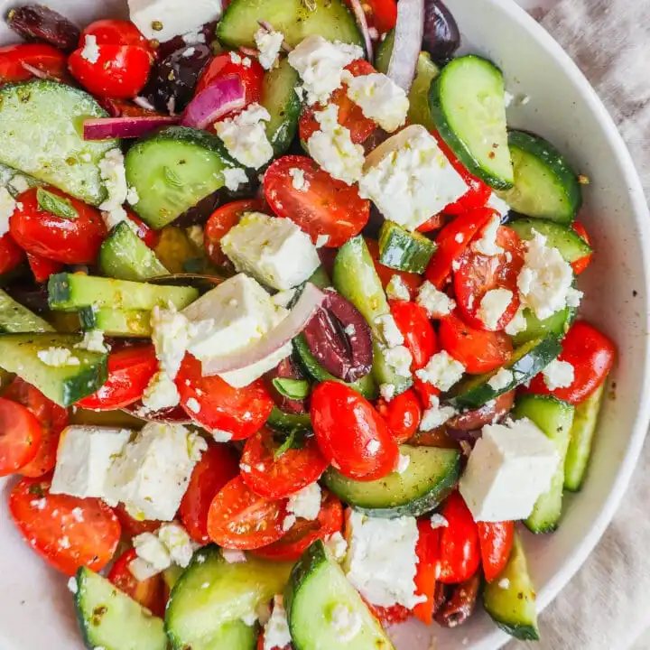 This simple Greek Salad is made with fresh tomatoes, cucumbers, red onion, kalamata olives, feta cheese, and all tossed with a homemade tangy Greek dressing.