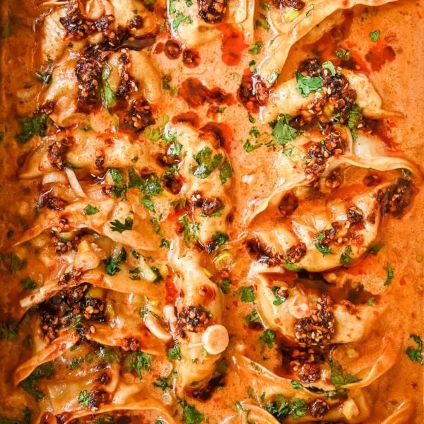 These viral baked dumplings from TikTok are the ultimate easy dinner hack! Crispy dumplings are baked in a creamy coconut curry sauce and topped with cilantro, chili crunch oil, and sesame seeds for the perfect mix of flavor and texture. This is an easy sheet pan dinner recipe!