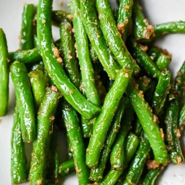 These Din Tai Fung green beans are crispy, blistered, and tossed with fresh garlic just like the famous restaurant version. A Chinese vegetable side dish that pairs perfectly with dumplings, noodles, or rice. The best copycat Din Tai Fung garlic green beans recipe!