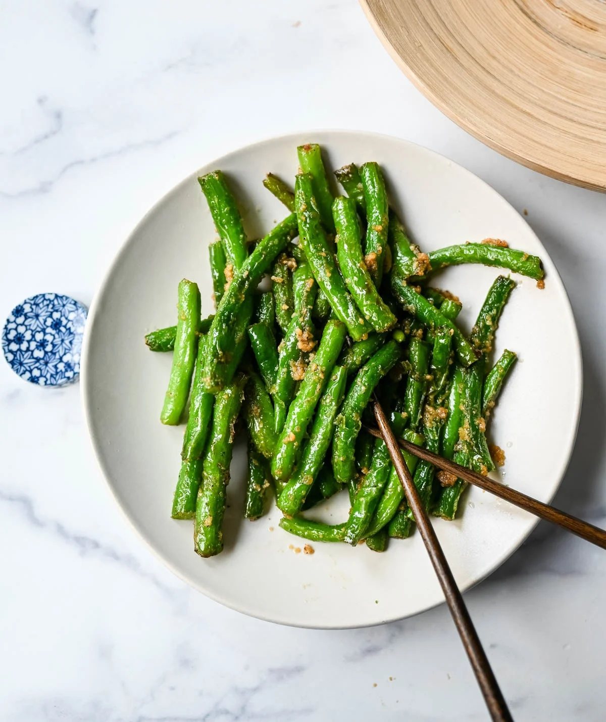 These Din Tai Fung green beans are crispy, blistered, and tossed with fresh garlic just like the famous restaurant version. A Chinese vegetable side dish that pairs perfectly with dumplings, noodles, or rice. The best copycat Din Tai Fung garlic green beans recipe!