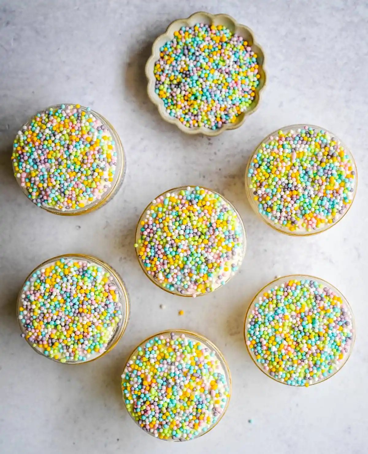 This viral dot cake recipe brings the NYC sprinkle cake trend straight to your kitchen — no trip to Butterfield Market required! Soft, buttery homemade yellow cake layered in a cup, topped with creamy vanilla buttercream, and completely coated in rainbow nonpareil sprinkles for that irresistible crunch. This easy homemade version is better than any boxed mix recipe you'll find — and takes less than an hour to make!