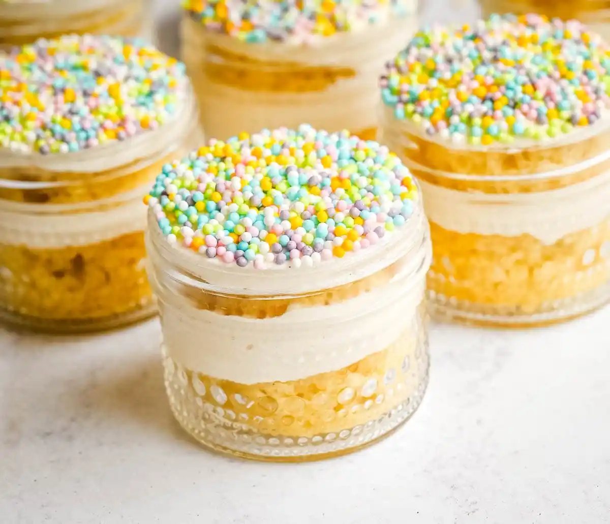 This viral dot cake recipe brings the NYC sprinkle cake trend straight to your kitchen — no trip to Butterfield Market required! Soft, buttery homemade yellow cake layered in a cup, topped with creamy vanilla buttercream, and completely coated in rainbow nonpareil sprinkles for that irresistible crunch. This easy homemade version is better than any boxed mix recipe you'll find — and takes less than an hour to make!