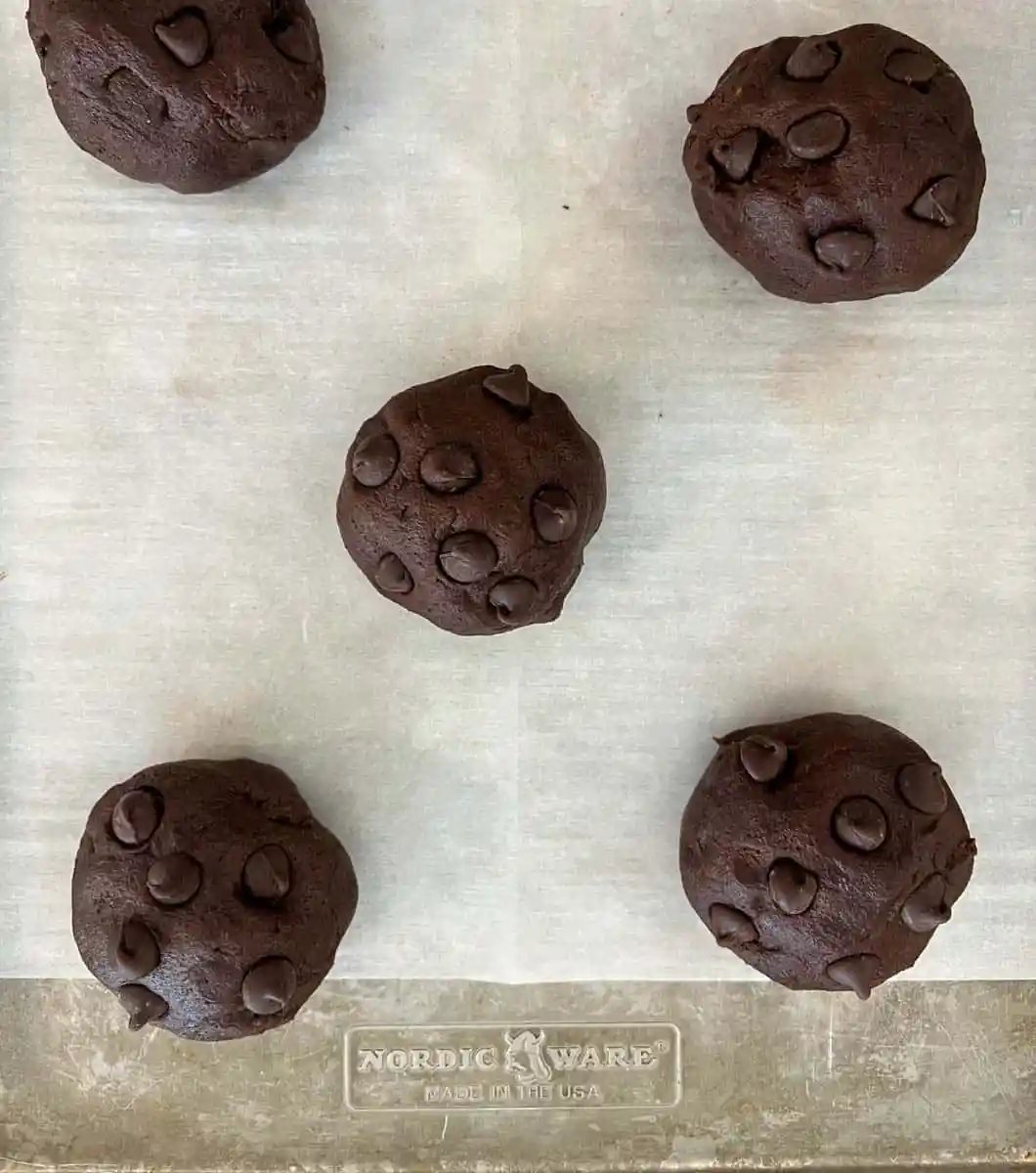 Balls of cookie dough placed on a baking sheet.
