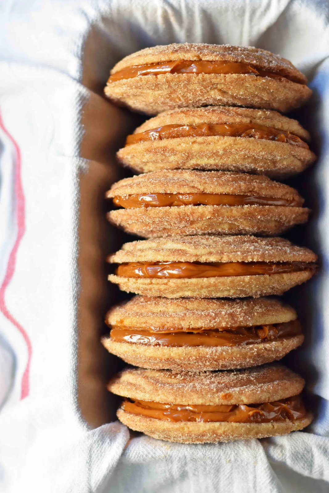 Dulce de Leche Cinnamon Sandwich Cookies. Cinnamon sugar snickerdoodles cookies stuffed with buttery dulce de leche caramel. A cinnamon sugar caramel cookie. www.modernhoney.com