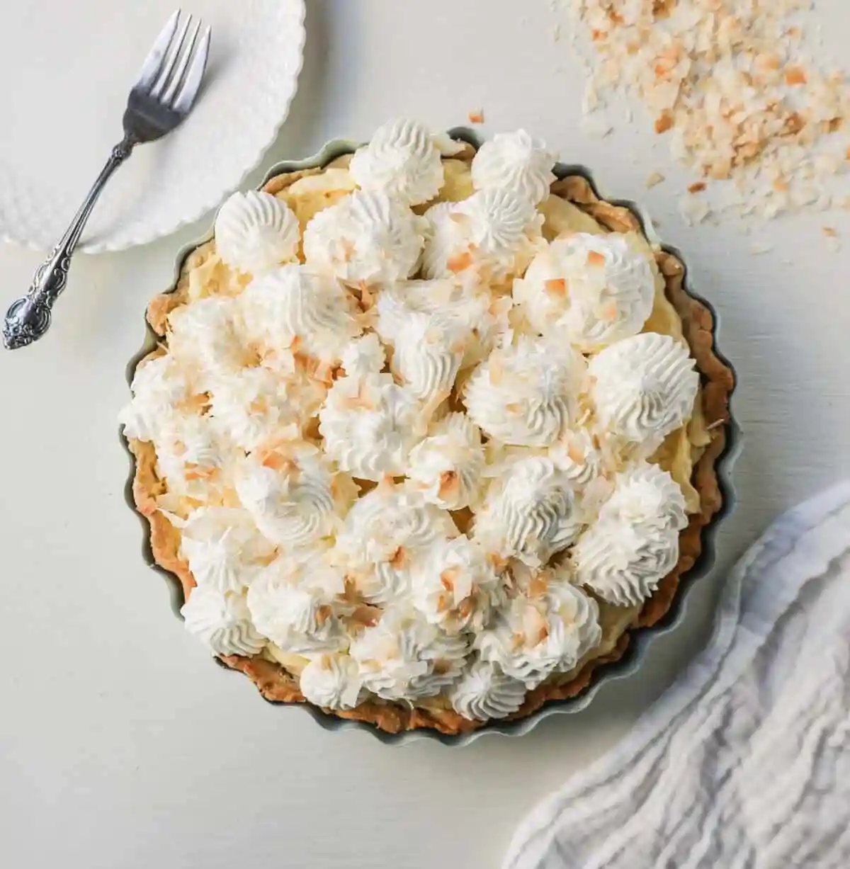 Easy Homemade Coconut Cream Pie made with pudding mix, sweetened condensed milk, whole milk, whipped cream, and sweetened shredded coconut all in a buttery pie crust and topped with sweet whipped cream. This is the best coconut cream pie recipe!