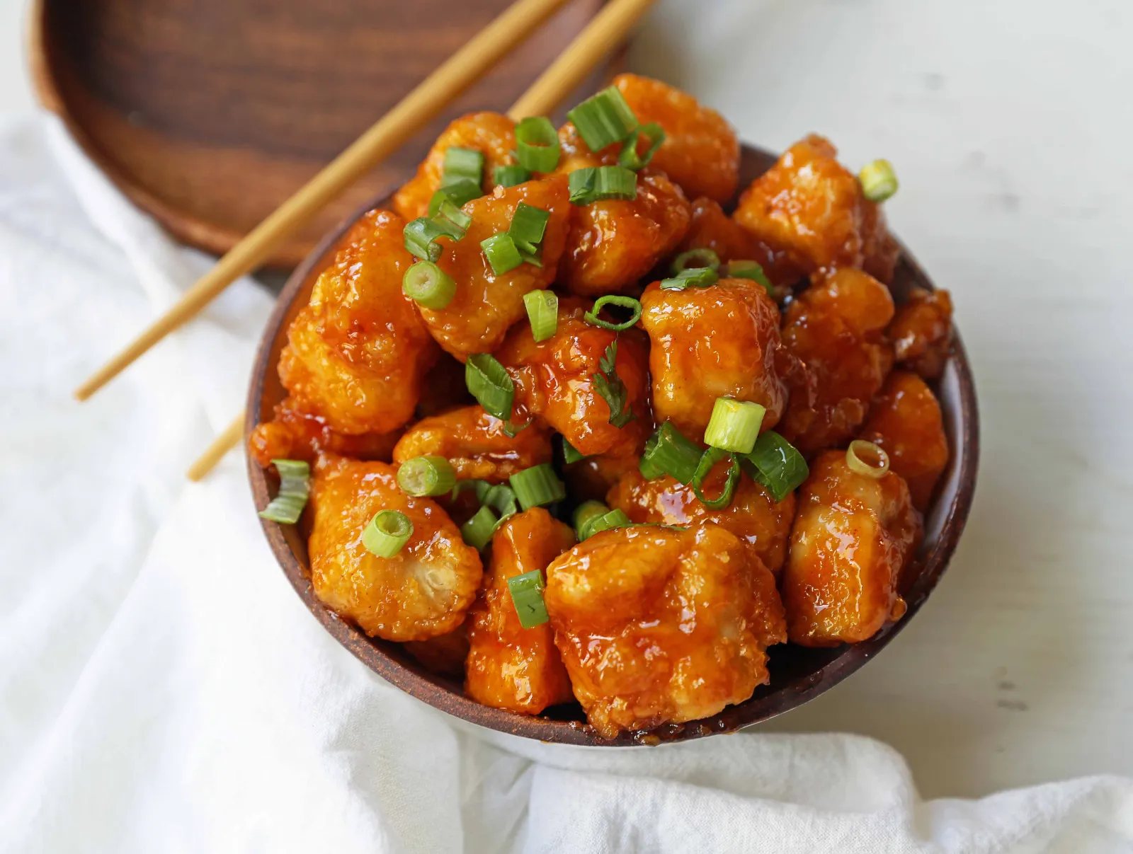 Firecracker Chicken. Sweet and spicy chicken bites made with tender chicken, flash-fried, and baked in a sweet brown sugar buffalo sauce. You'll have people coming back for seconds in no time at all! www.modernhoney.com #firecrackerchicken #buffalochicken #chicken #chickenbites