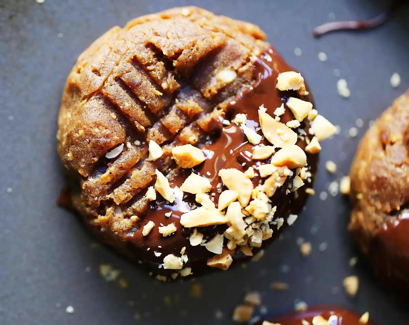 Flourless Chocolate Dipped Peanut Butter Cookies. Healthy peanut butter cookies dipped in dark chocolate. All-natural peanut butter cookies with only 5 ingredients! Flourless, butterless, peanut butter dark chocolate cookies. www.modernhoney.com #healthycookies #chocolatepeanutbutter #peanutbuttercookies #datecookies #peanutbutterdatecookies #chocolatepeanutbutter #cookierecipes