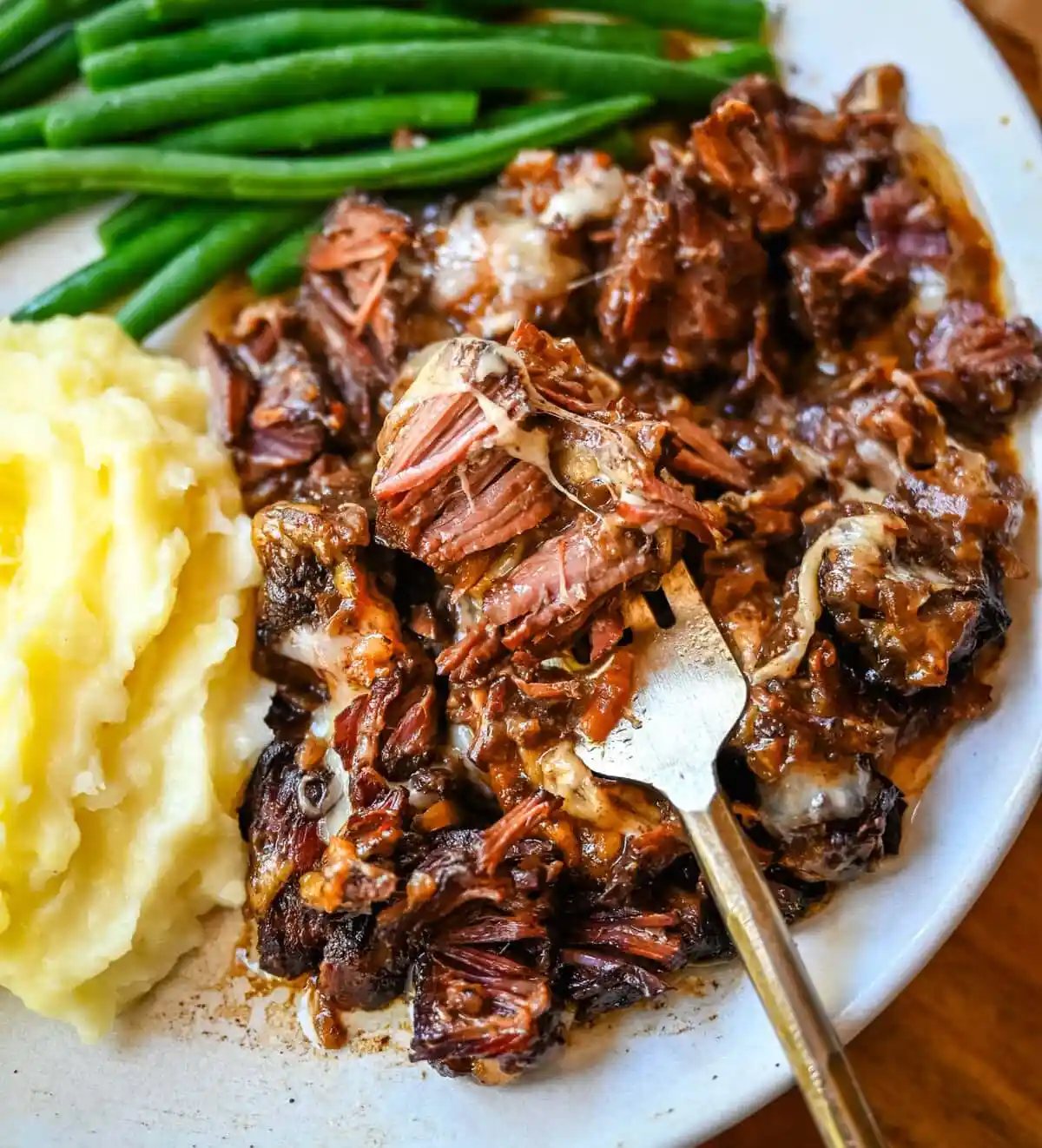 This French Onion Pot Roast recipe is made in your slow cooker for a set-it-and-forget-it meal packed with flavor. With sweet caramelized onions, beefy broth, and gooey Gruyère cheese, it's truly the best savory beef pot roast recipe!