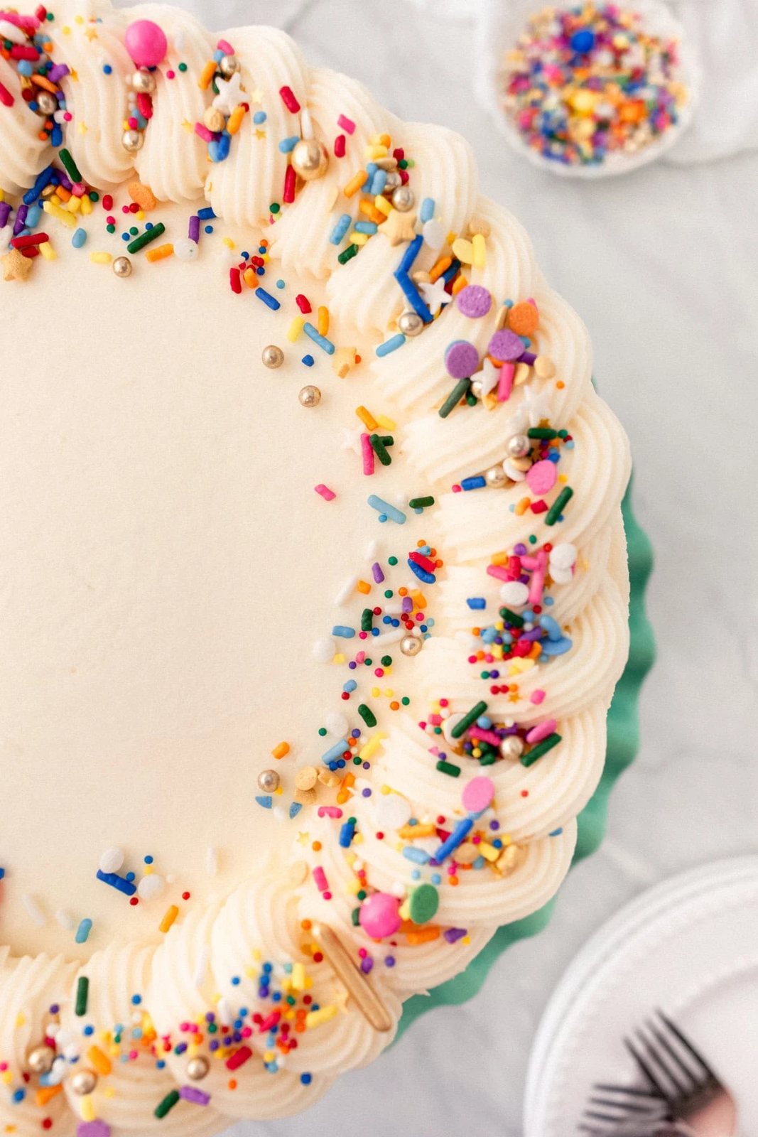 A layered funfetti or confetti cake with sprinkles. A fluffy homemade Funfetti birthday cake with rainbow sprinkles topped with a light cream cheese buttercream frosting and an array of sprinkles. This Confetti Cake recipe is the perfect birthday cake!