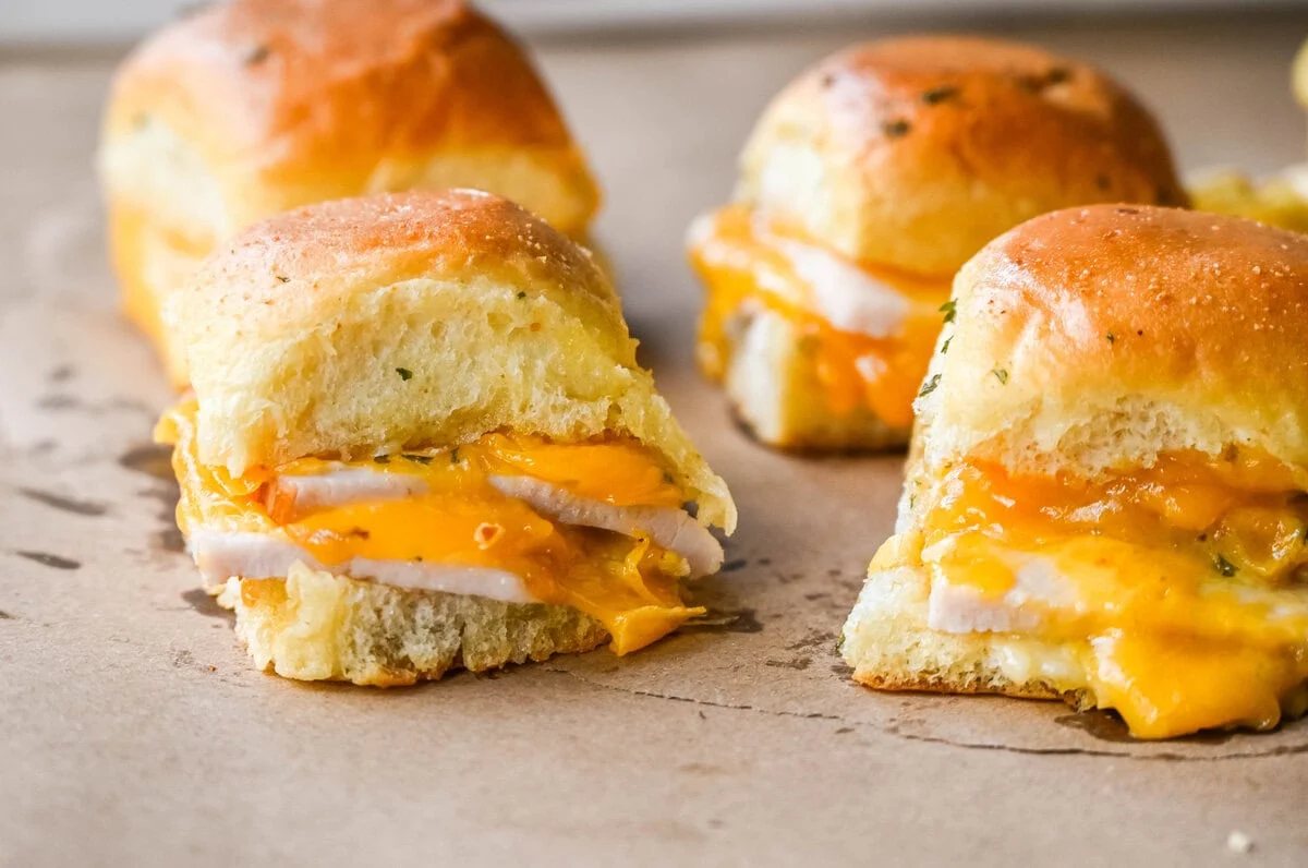 Garlic Herb Turkey and Cheddar Sliders. These Baked Turkey and Cheddar Sliders on Hawaiian Rolls with a sweet honey mustard spread and homemade garlic butter brushed on top are the perfect turkey slider recipe.