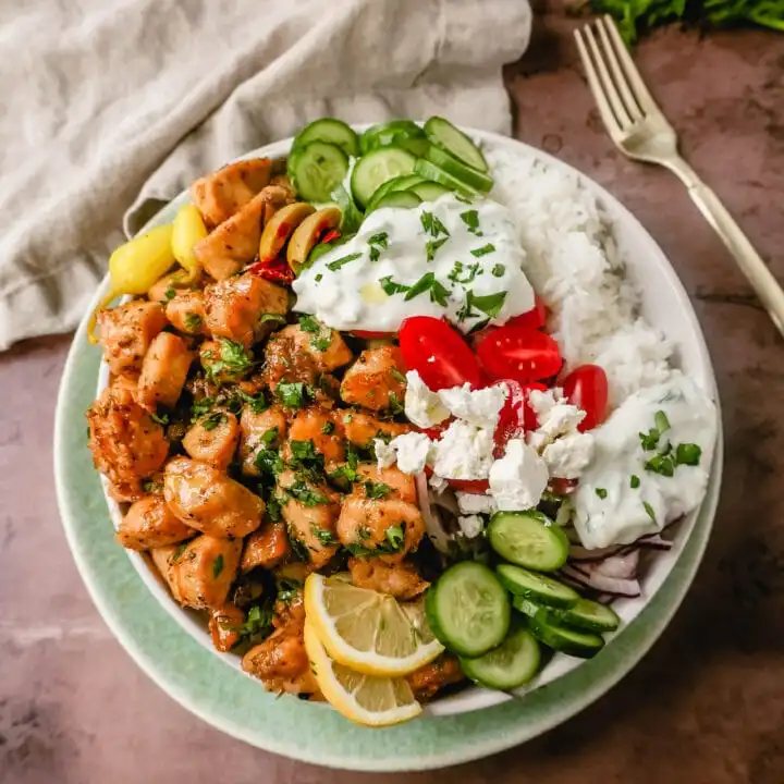 How to make the Best Greek Chicken Bowls. Grilled Greek Lemon Chicken, cucumber, tomatoes, red onion, kalamata olives, feta cheese, and homemade tzatziki sauce all in one bowl. A high-protein and low-carb meal!