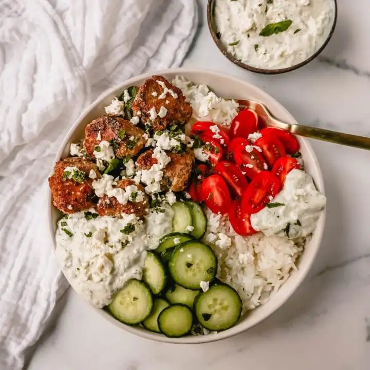 Greek Chicken Meatballs are moist and flavorful without any fillers...just spices and herbs. These Greek Turkey Meatballs are served with homemade tzatziki sauce, fresh cucumbers, tomatoes, and rice.