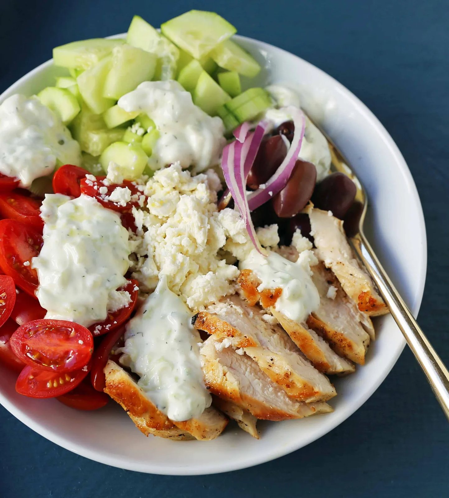 Greek Chicken Bowls. Grilled Greek Lemon Chicken, cucumber, tomatoes, red onion, kalamata olives, feta cheese, and homemade tzatziki sauce all in one bowl. A high-protein and low carb meal! www.modernhoney.com #greekchickenbowls #greekchickenbowl #greekfood #glutenfree