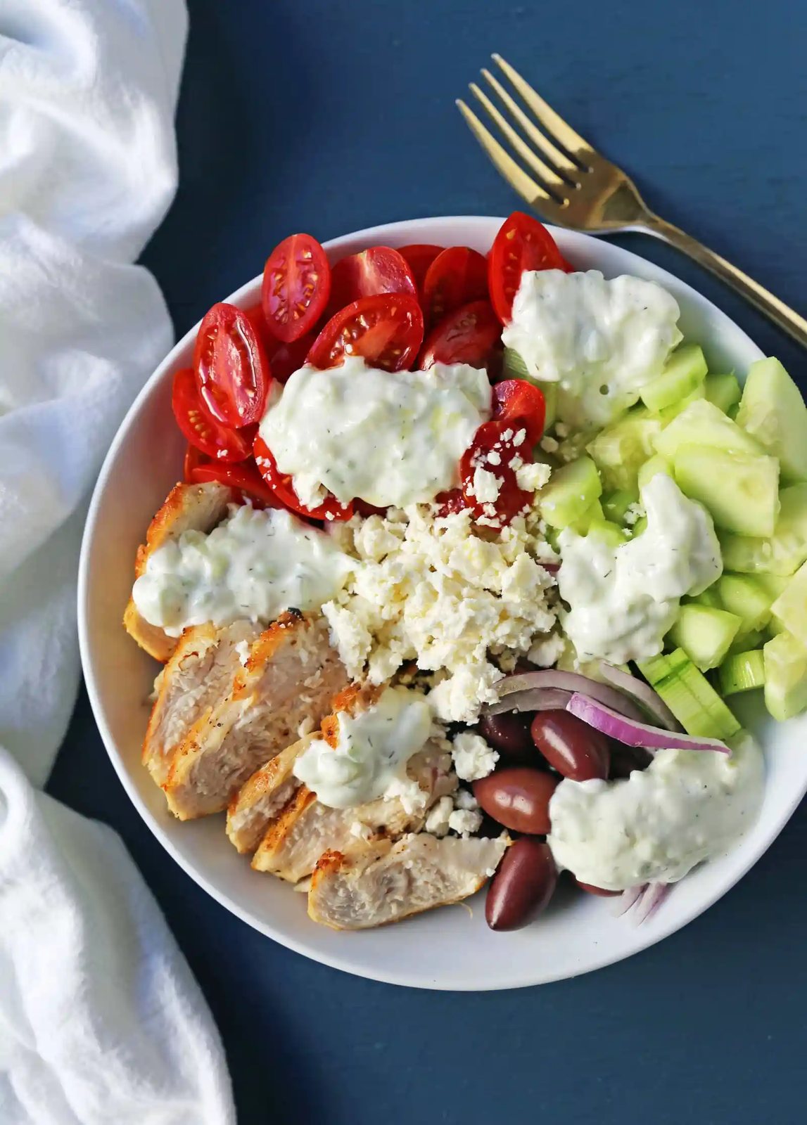 Greek Chicken Bowls. Grilled Greek Lemon Chicken, cucumber, tomatoes, red onion, kalamata olives, feta cheese, and homemade tzatziki sauce all in one bowl. A high-protein and low carb meal! www.modernhoney.com #greekchickenbowls #greekchickenbowl #greekfood #glutenfree