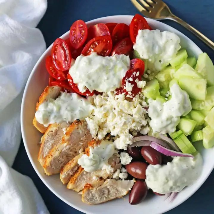 Greek Chicken Bowls. Grilled Greek Lemon Chicken, cucumber, tomatoes, red onion, kalamata olives, feta cheese, and homemade tzatziki sauce all in one bowl. A high-protein and low carb meal! www.modernhoney.com #greekchickenbowls #greekchickenbowl #greekfood #glutenfree
