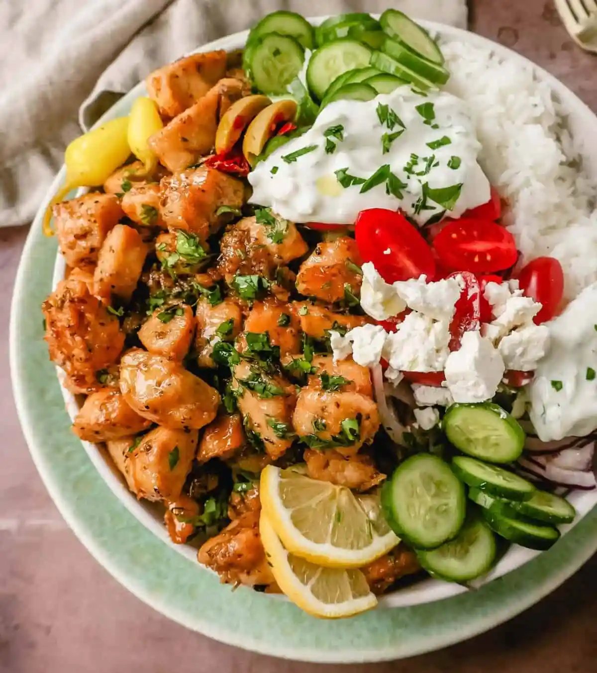 How to make the Best Greek Chicken Bowls. Grilled Greek Lemon Chicken, cucumber, tomatoes, red onion, kalamata olives, feta cheese, and homemade tzatziki sauce all in one bowl. A high-protein and low-carb meal!
