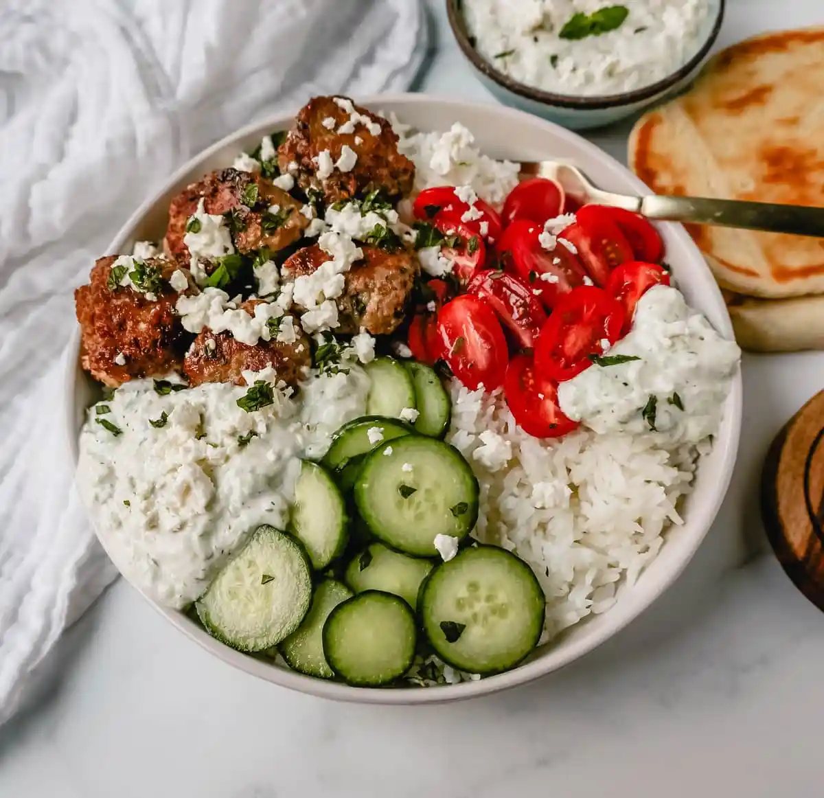 Greek Chicken Meatballs are moist and flavorful without any fillers...just spices and herbs. These Greek Turkey Meatballs are served with homemade tzatziki sauce, fresh cucumbers, tomatoes, and rice.