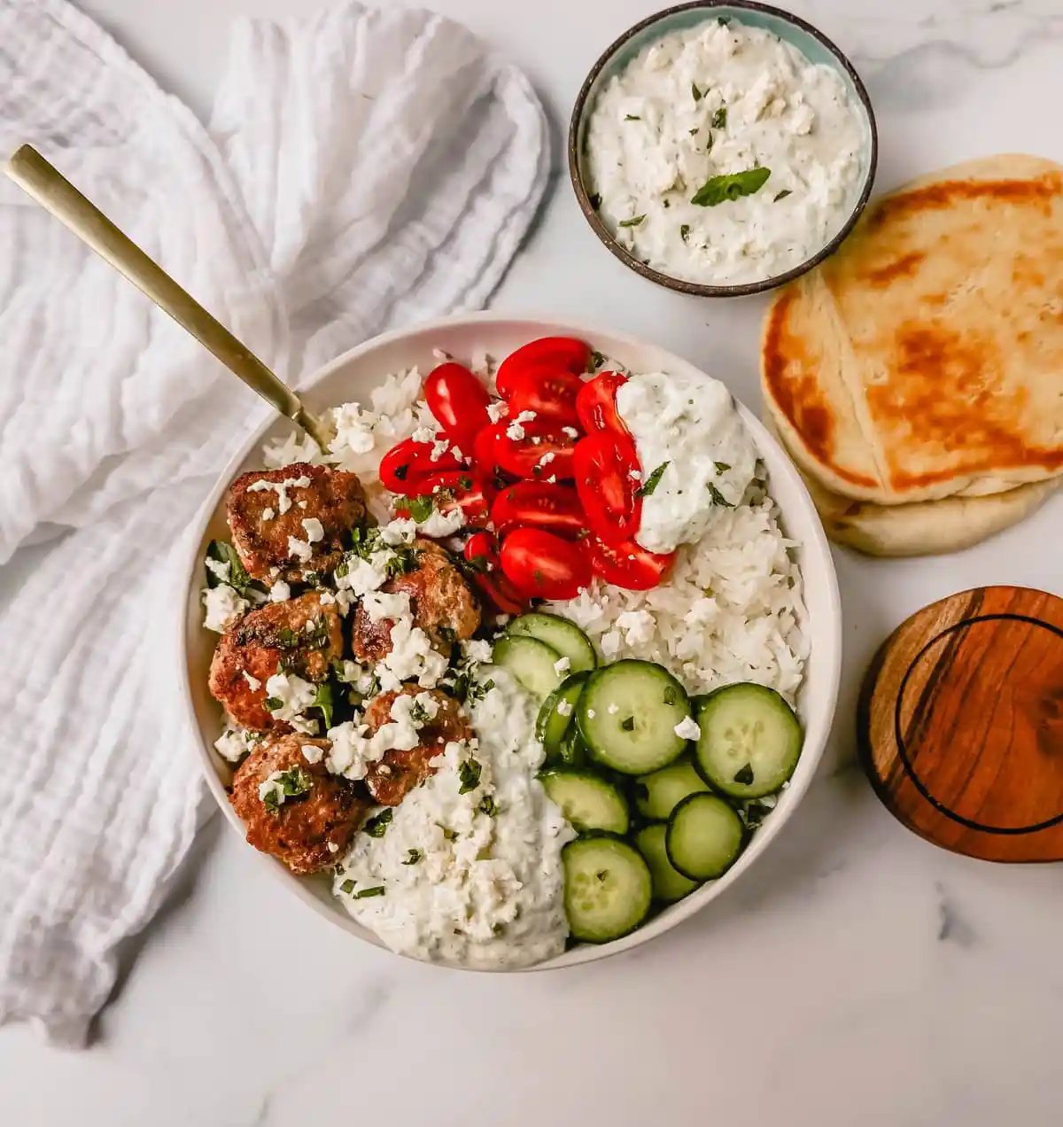 Greek Chicken Meatballs are moist and flavorful without any fillers...just spices and herbs. These Greek Turkey Meatballs are served with homemade tzatziki sauce, fresh cucumbers, tomatoes, and rice.