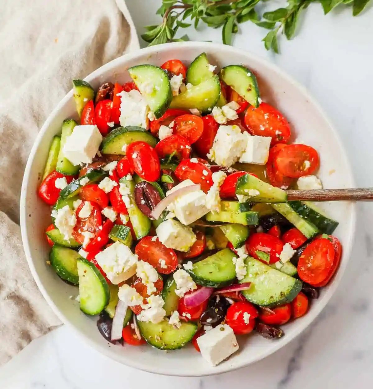 This simple Greek Salad is made with fresh tomatoes, cucumbers, red onion, kalamata olives, feta cheese, and all tossed with a homemade tangy Greek dressing.