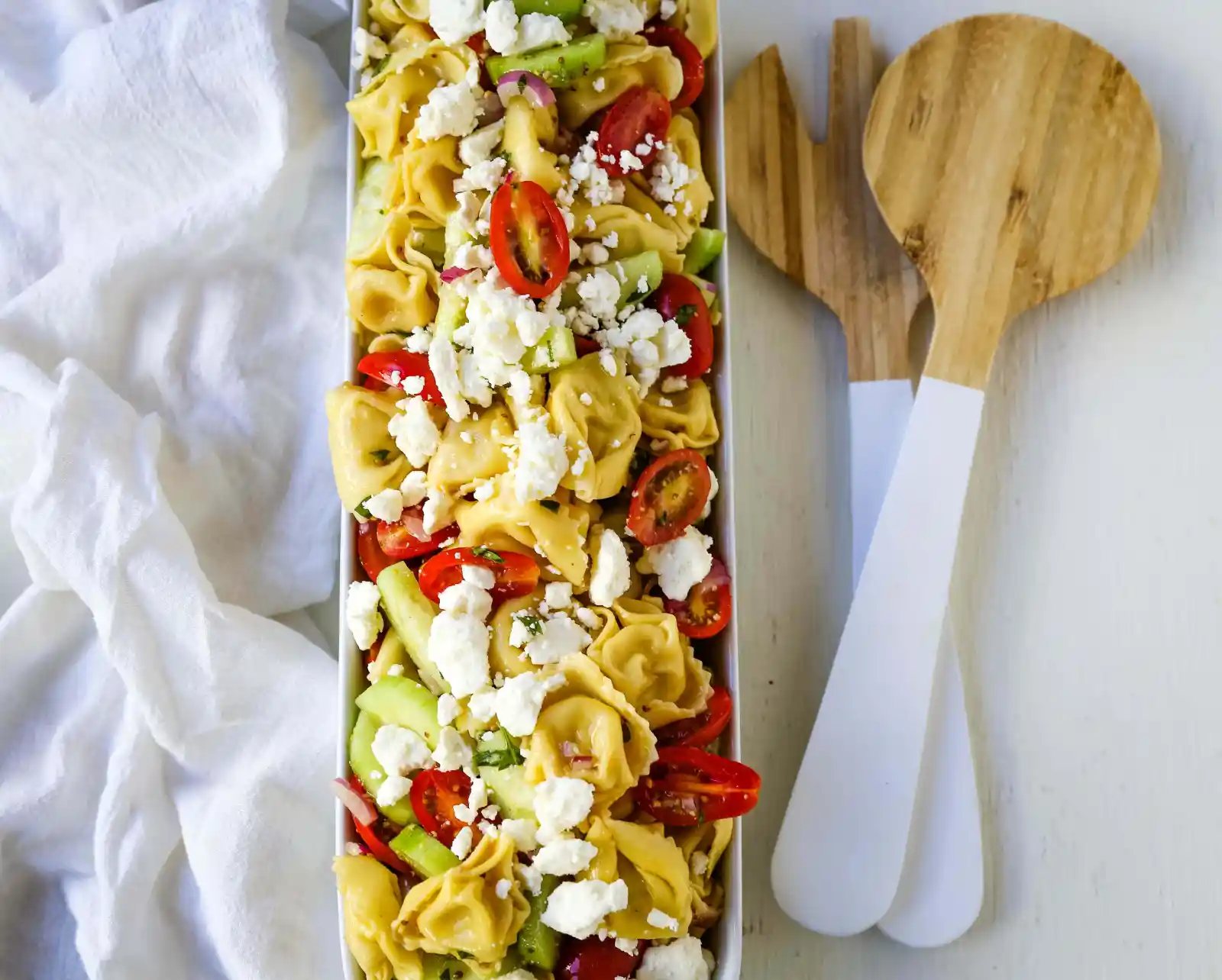 Greek Tortellini Pasta Salad. Cheese Tortellini Pasta tossed with fresh tomatoes, cucumbers, red onion, feta cheese, in a homemade Greek dressing. www.modernhoney.com #sidedish #pastasalad #salad #potluck