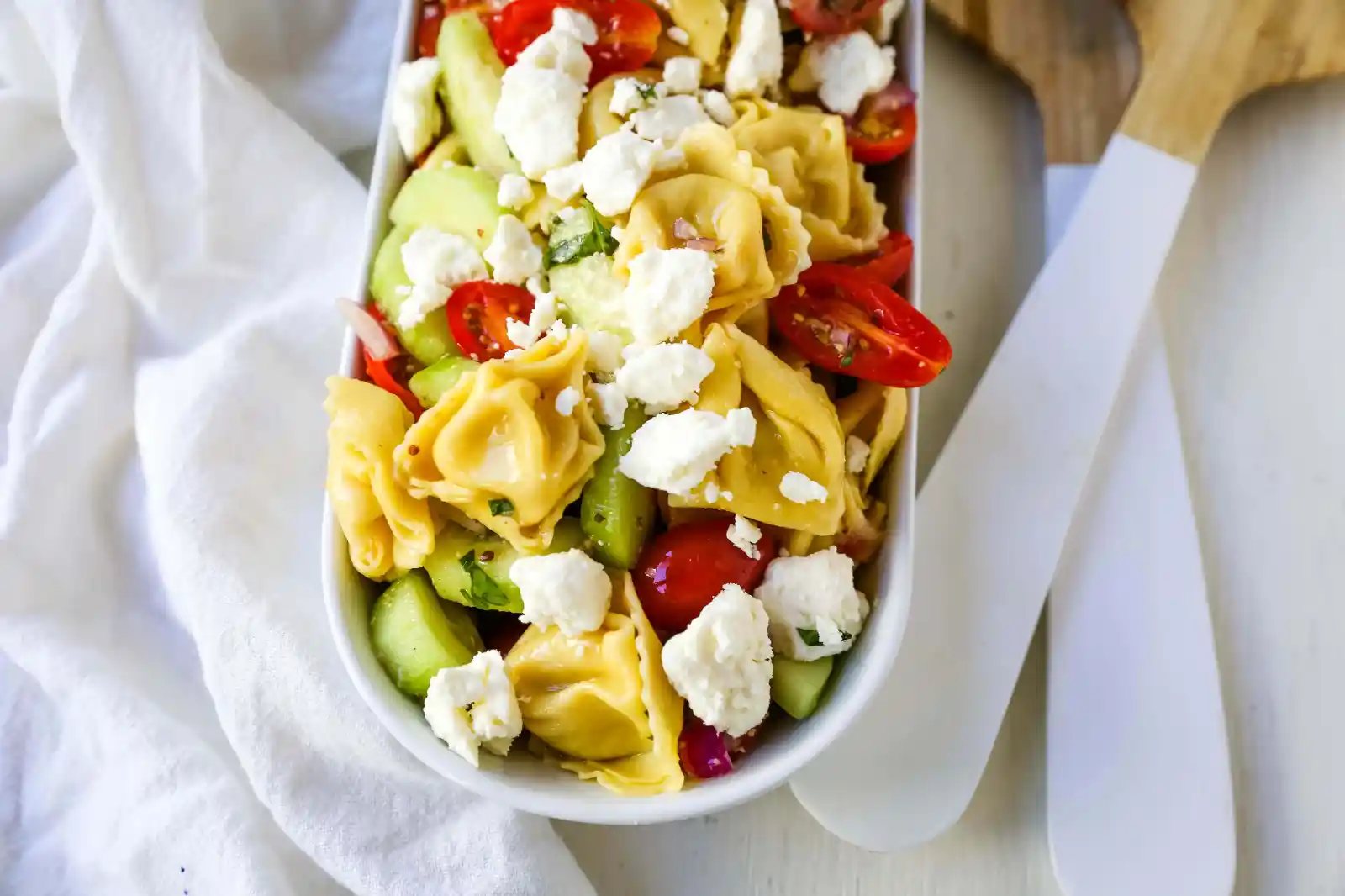 Greek Tortellini Pasta Salad. Cheese Tortellini Pasta tossed with fresh tomatoes, cucumbers, red onion, feta cheese, in a homemade Greek dressing. www.modernhoney.com #sidedish #pastasalad #salad #potluck