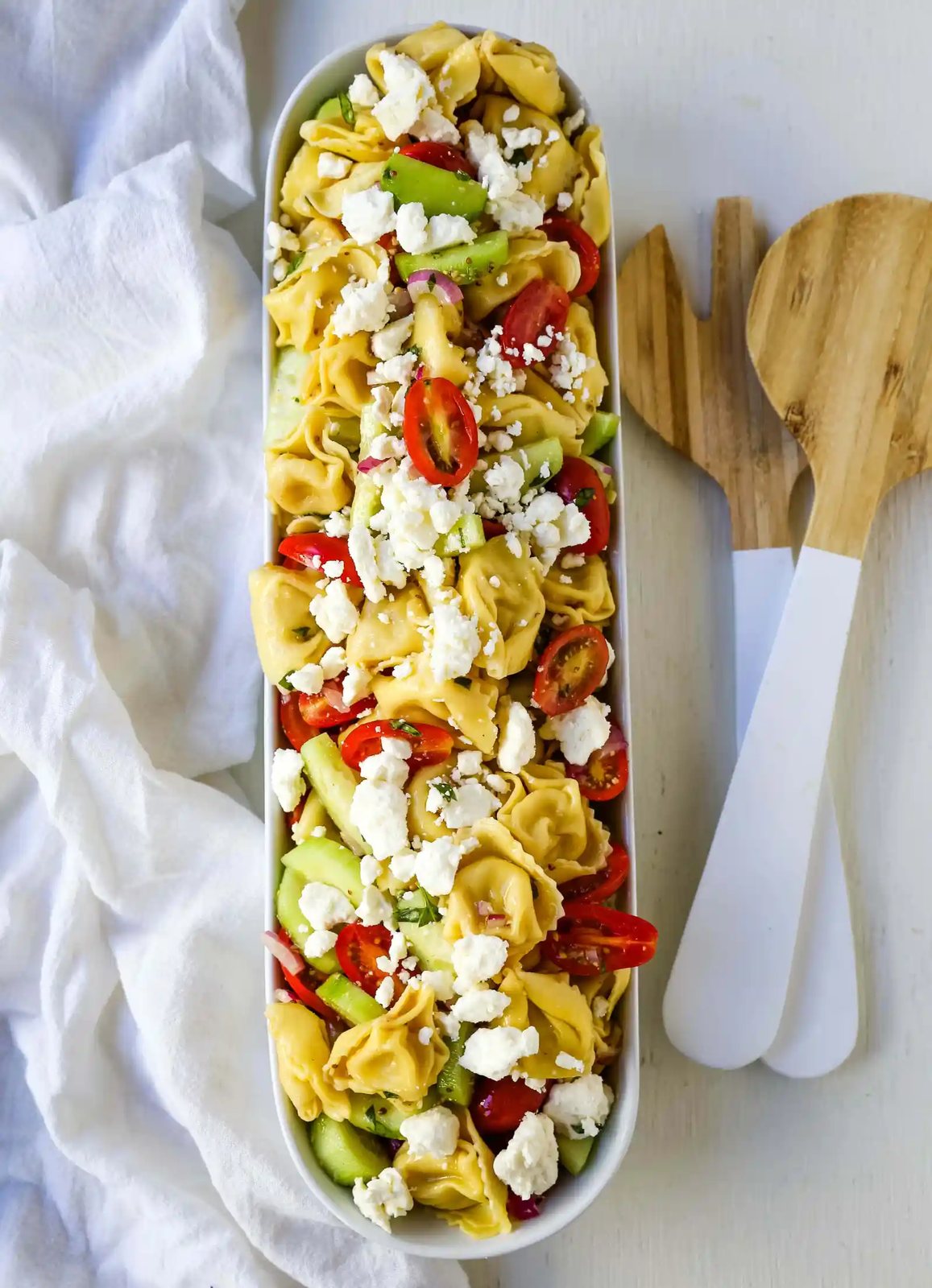Greek Tortellini Pasta Salad. Cheese Tortellini Pasta tossed with fresh tomatoes, cucumbers, red onion, feta cheese, in a homemade Greek dressing. www.modernhoney.com #sidedish #pastasalad #salad #potluck