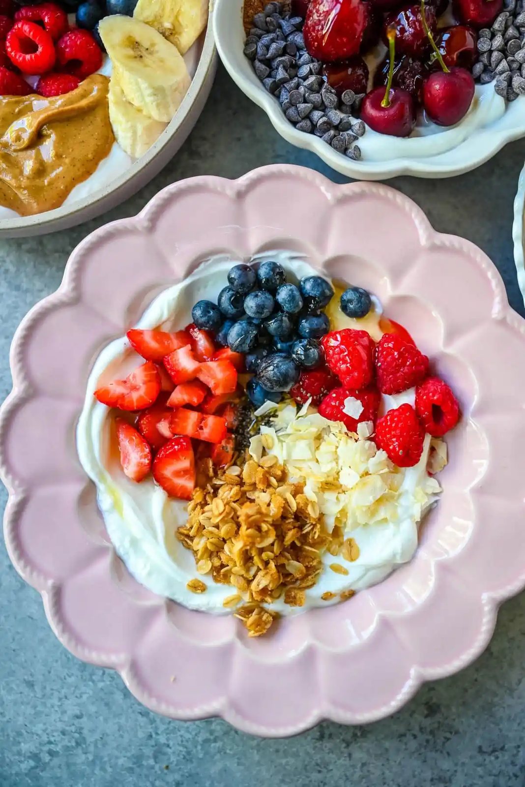 Greek Yogurt breakfast bowl with greek yogurt, strawberries, blueberries, coconut flakes, and granola.