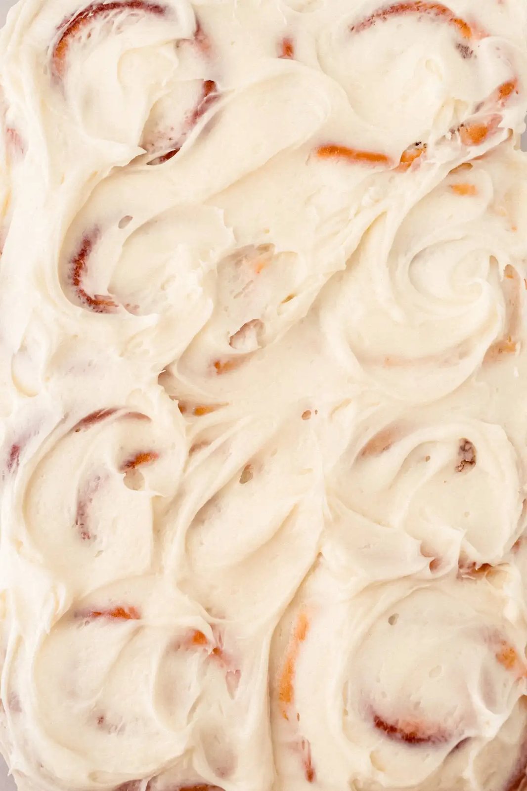 Frosted homemade cinnamon rolls with cream cheese frosting.