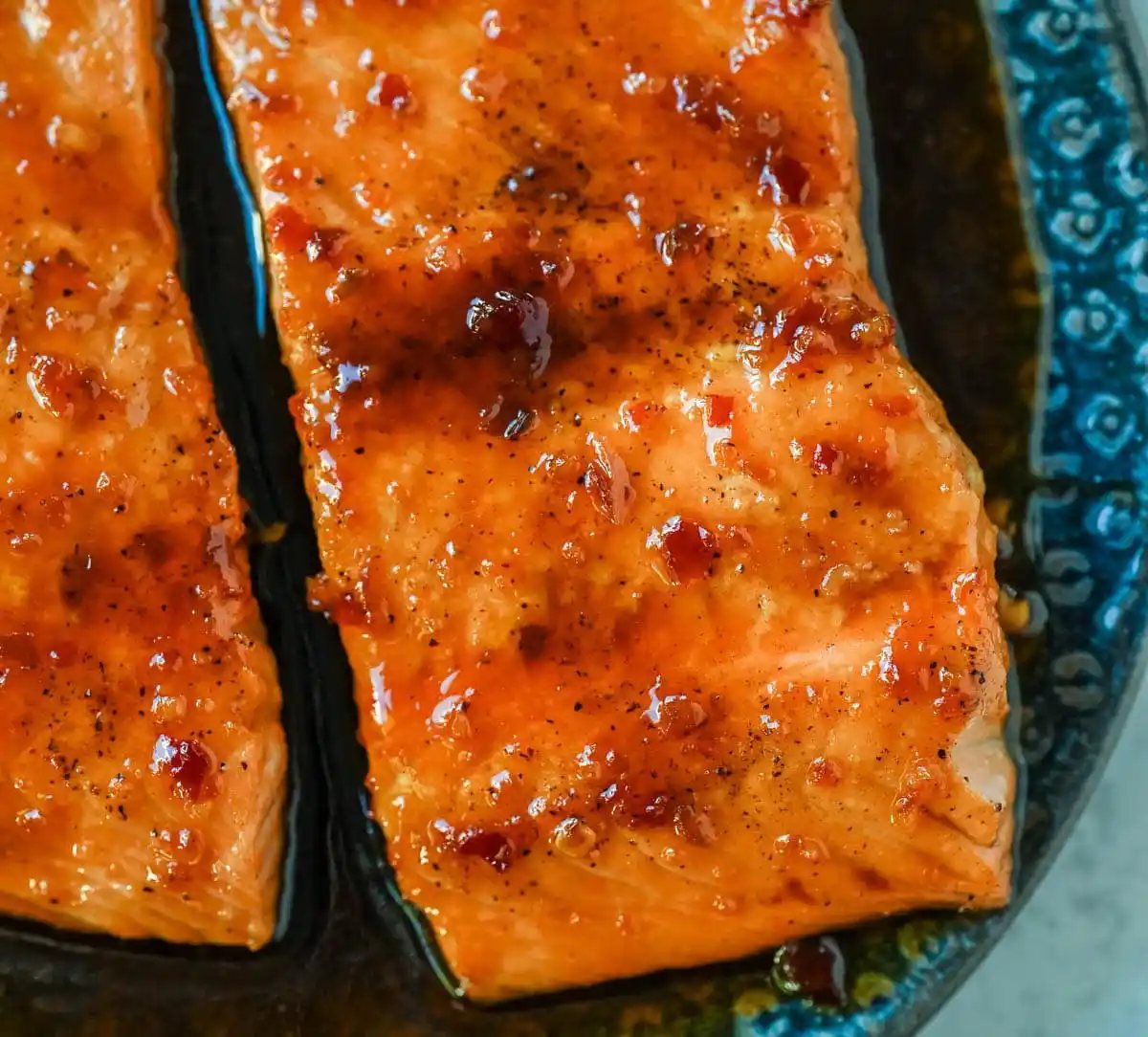 The Best Honey Garlic Glazed Salmon (Sticky, Sweet & Spicy) is the most incredible easy weeknight dinner recipe that comes together in just one pan in under 20 minutes from start to finish. Sticky sweet and garlicky, this glazed salmon recipe is hands down the most addicting salmon you will ever make coated in a rich homemade honey garlic sauce made with butter, soy sauce, fresh lemon juice, and a kick of chili garlic sauce that takes every single bite completely over the top.